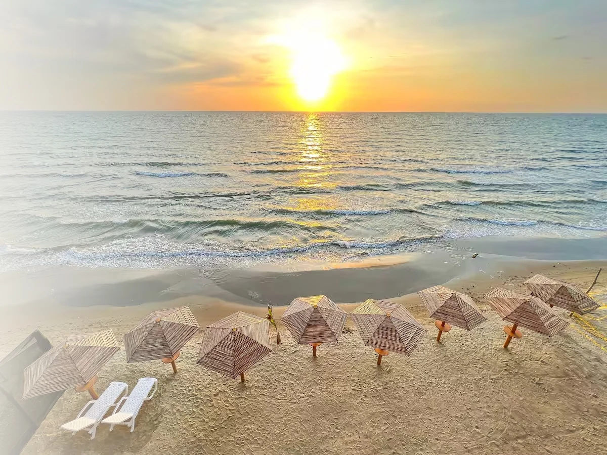 Atardecer sobre el mar y kioskos de playa en Coralina Lodge