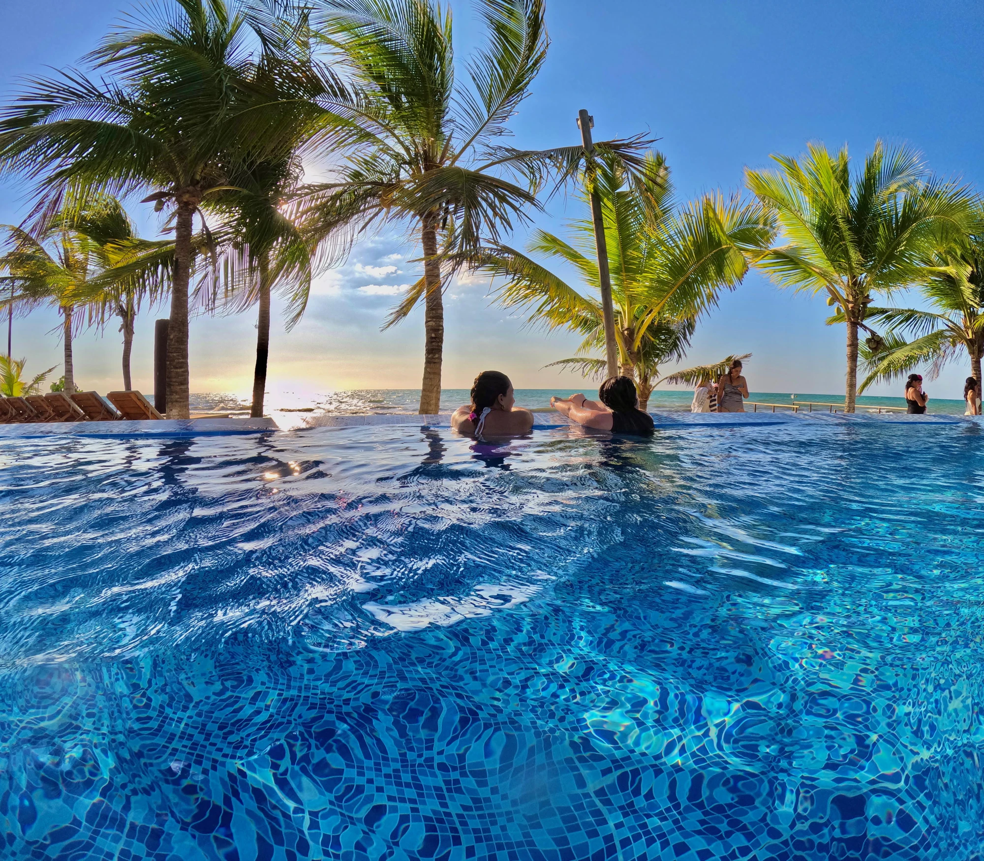 Piscina de Coralina frente al mar, rodeada de palmeras